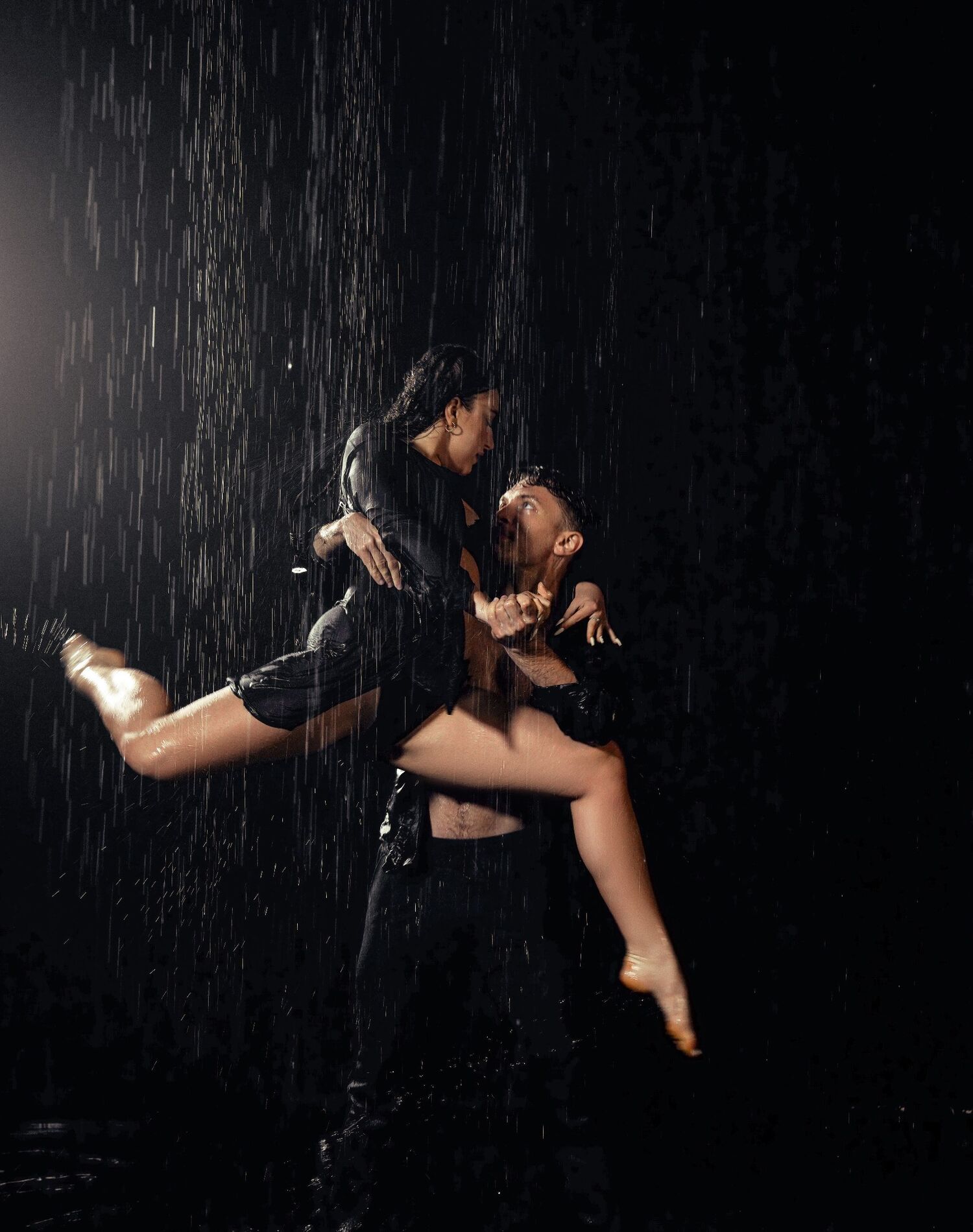 A couple dancing under the rain effect in the black area at JL Studios