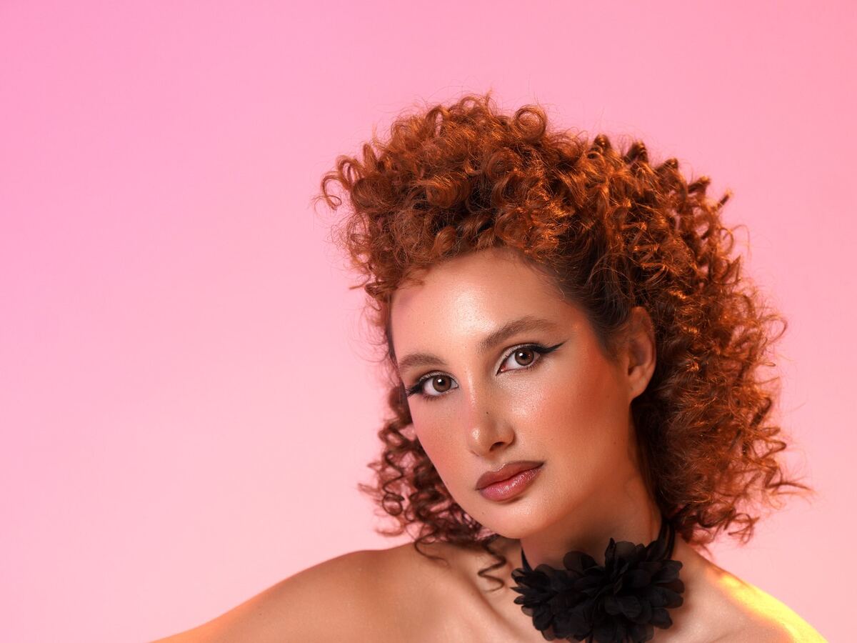 A beauty portrait lit with warm gels on the cyclorama